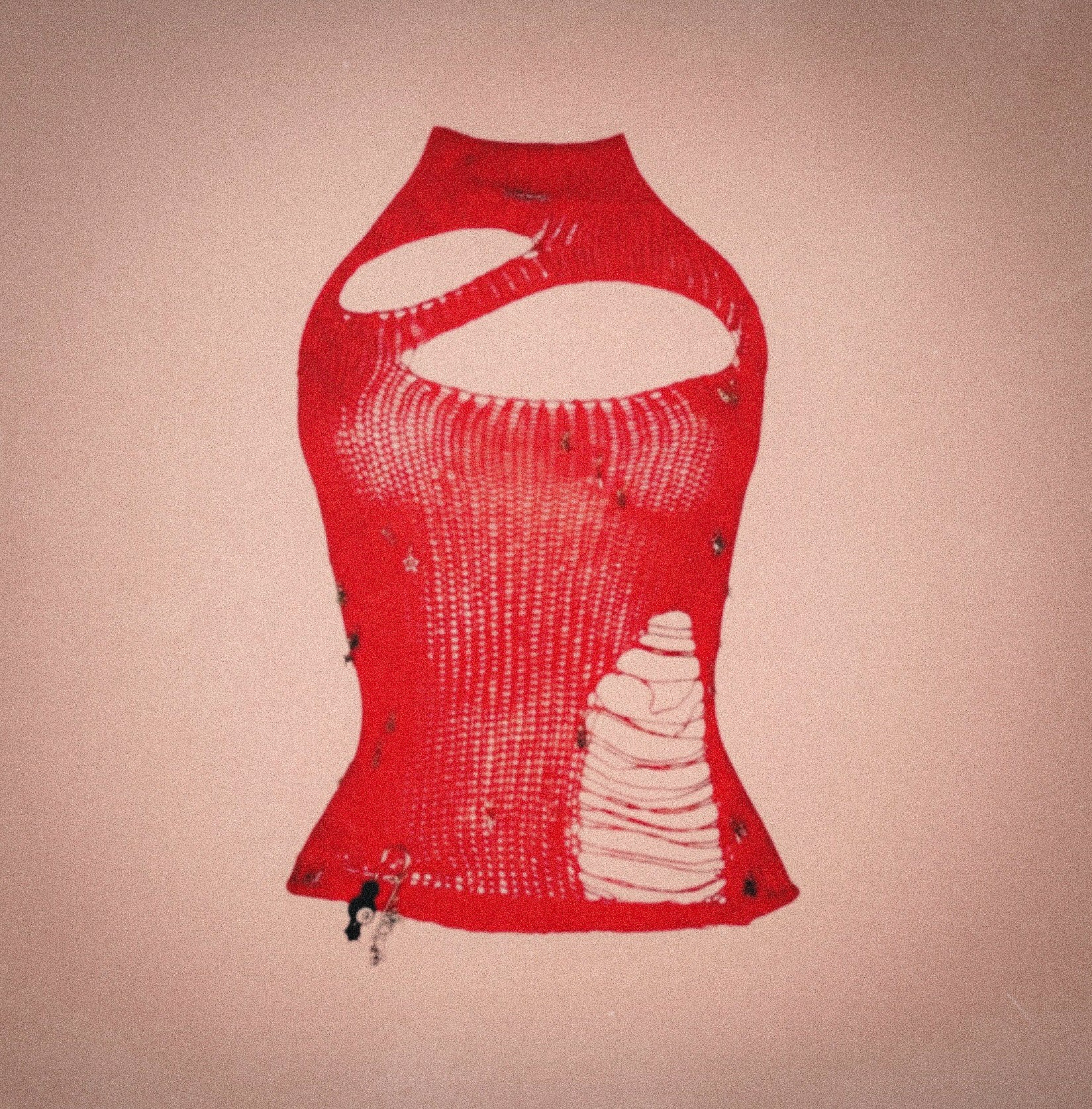 Red artisanal deconstructed halter top with shredded knit, sculptural asymmetrical cutouts and raw distressed detailing, photographed against a neutral textured backdrop.