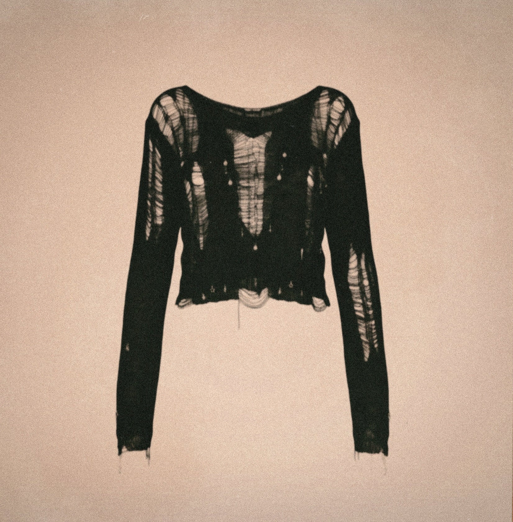 Black artisanal deconstructed mesh top with raw distressed knit, shredded texture and sculptural ANCHARÉ silhouette photographed on a neutral backdrop.
